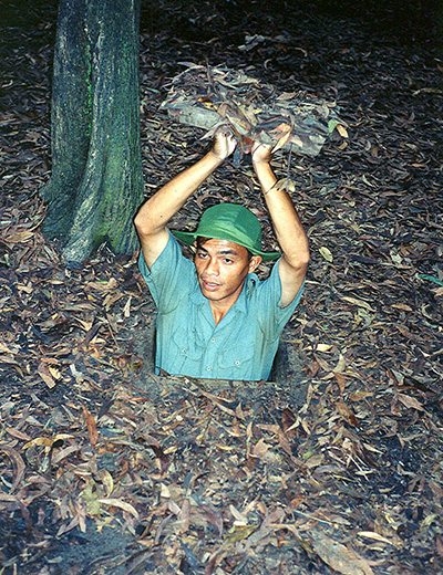 Cu Chi Tunnels, soldier shows us a camouflaged entrance